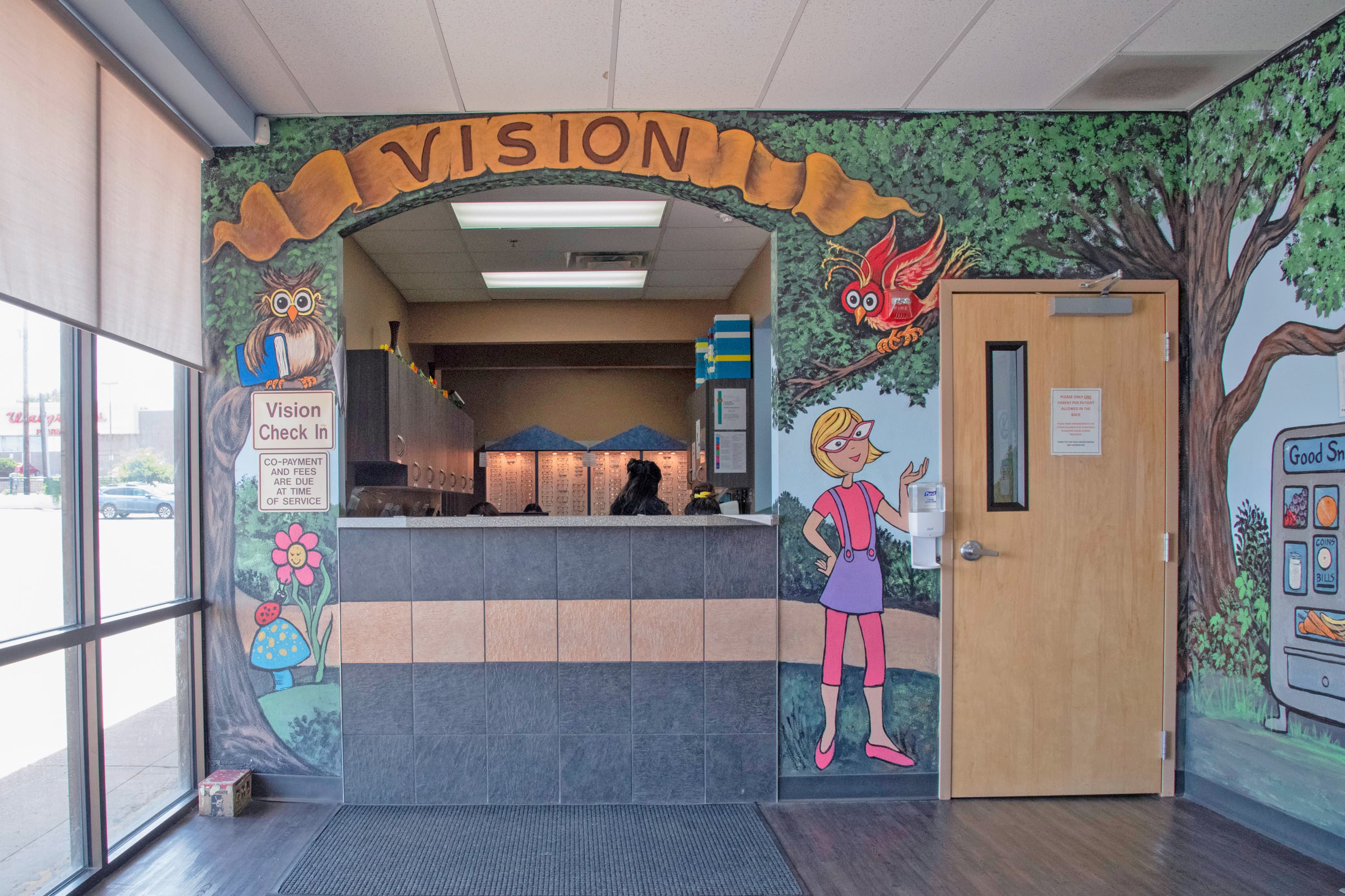 reception desk that says kid's vision with cartoon characters