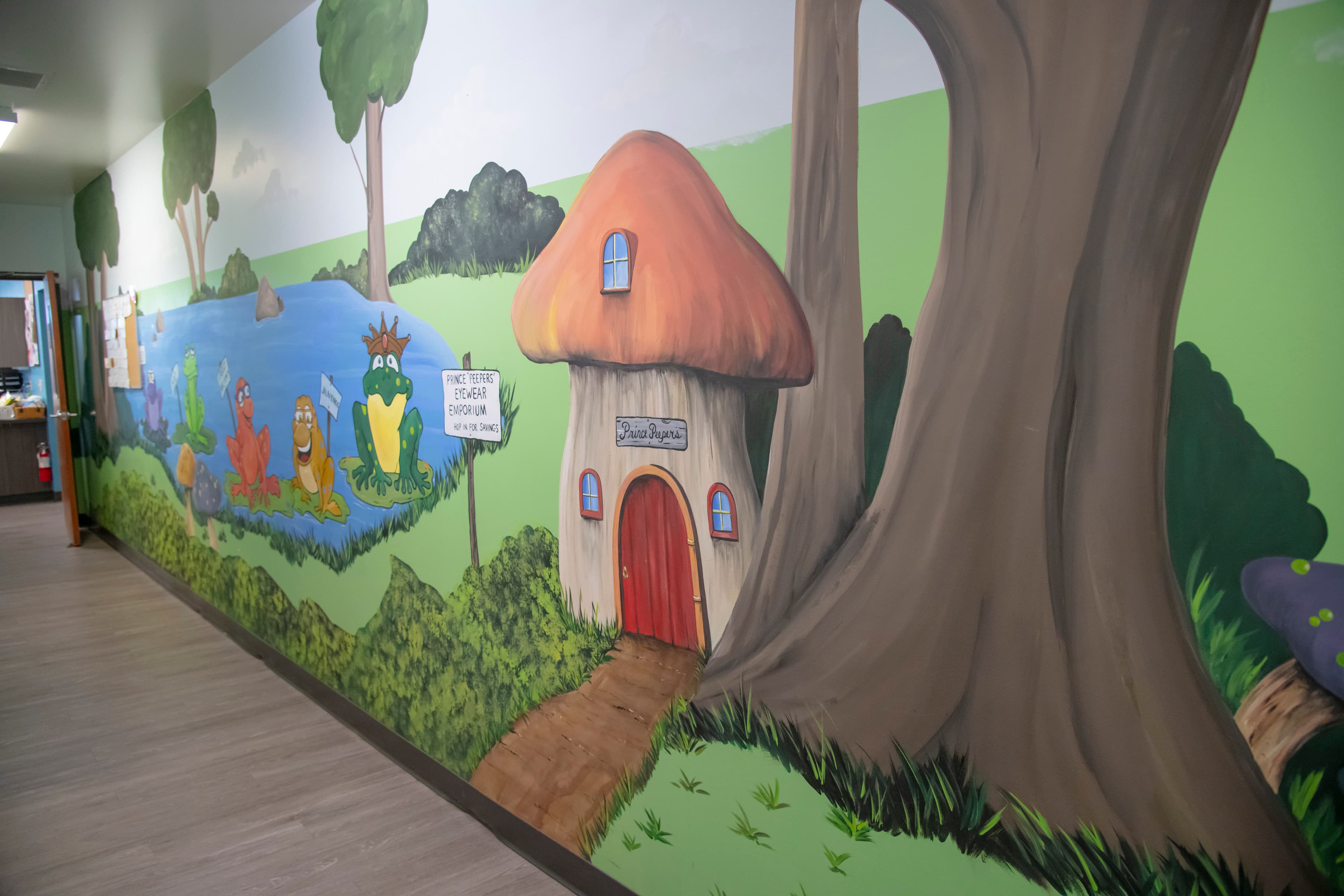 wall graphic in a dentist office with a mushroom house next to a tree