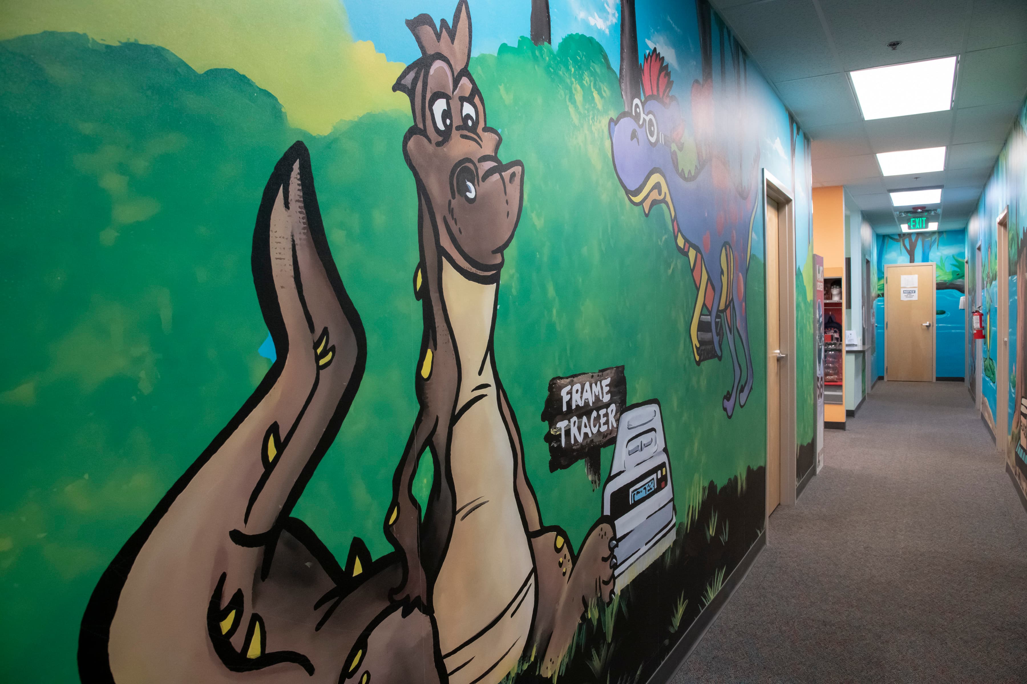 hallway with brown dinosaur and purple dinosaur painted on a wall