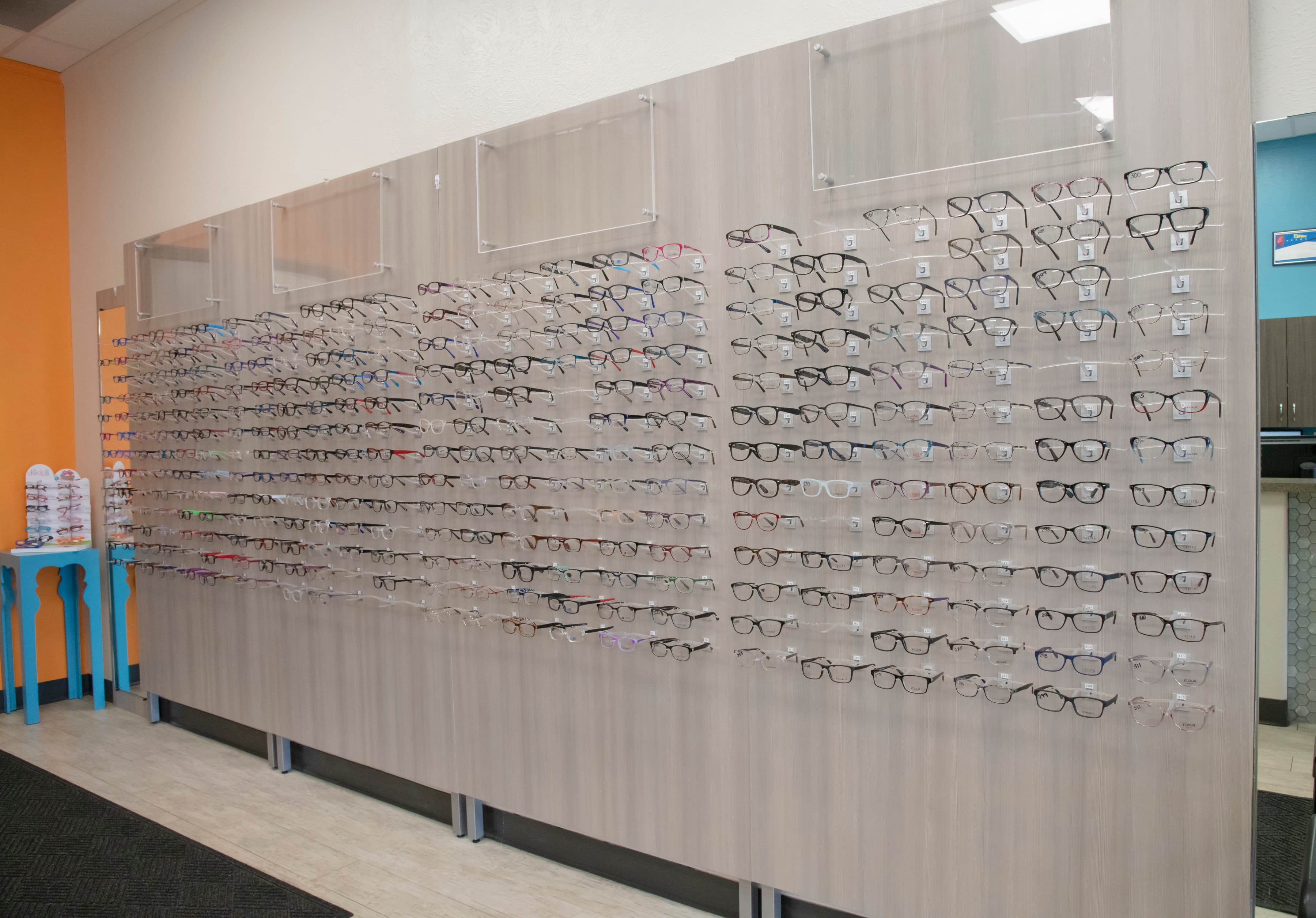a wall with hundreds of children's vision glasses displayed