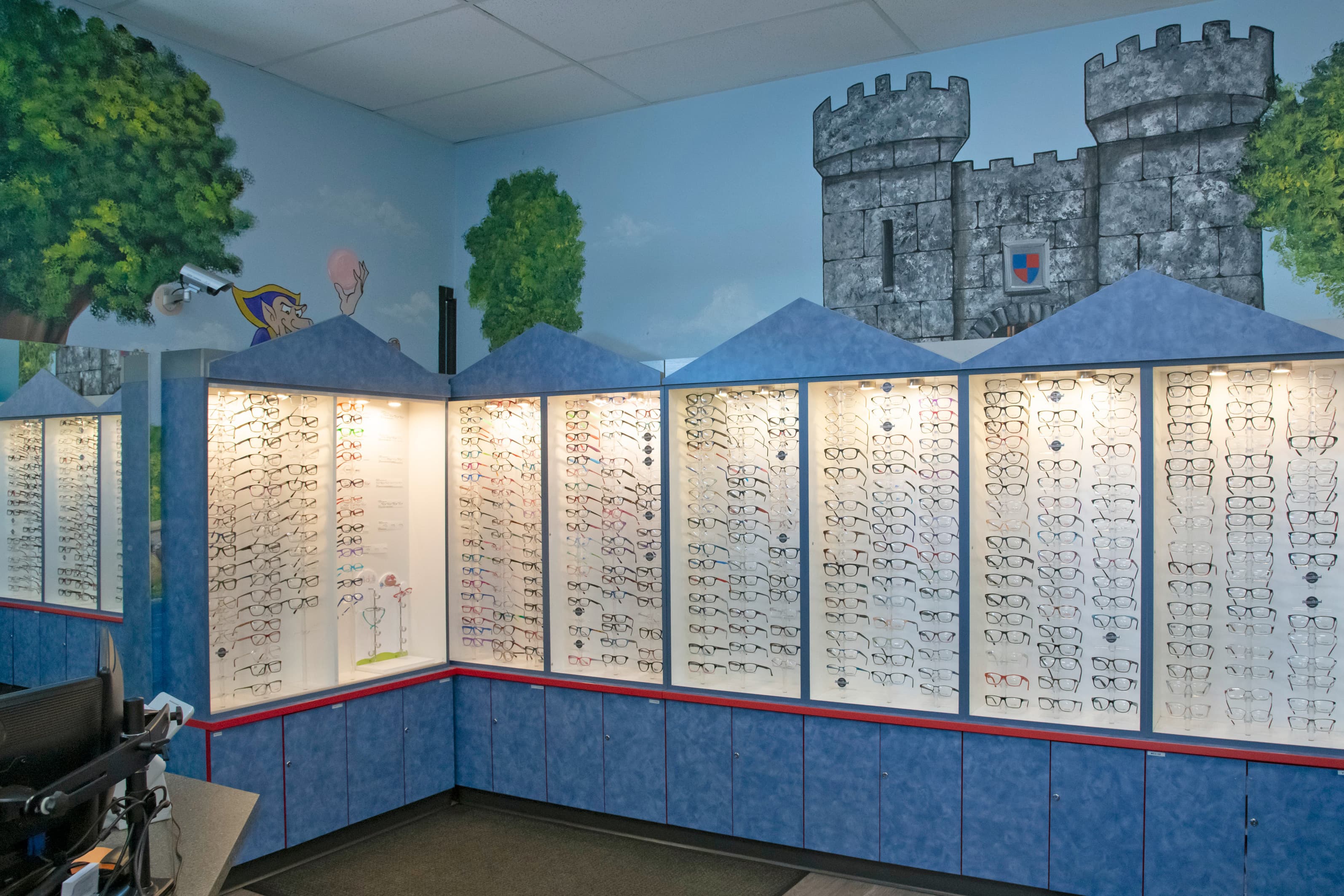 children's optometrist office in Colorado Springs with large display of children's glasses and a castle graphic in the background
