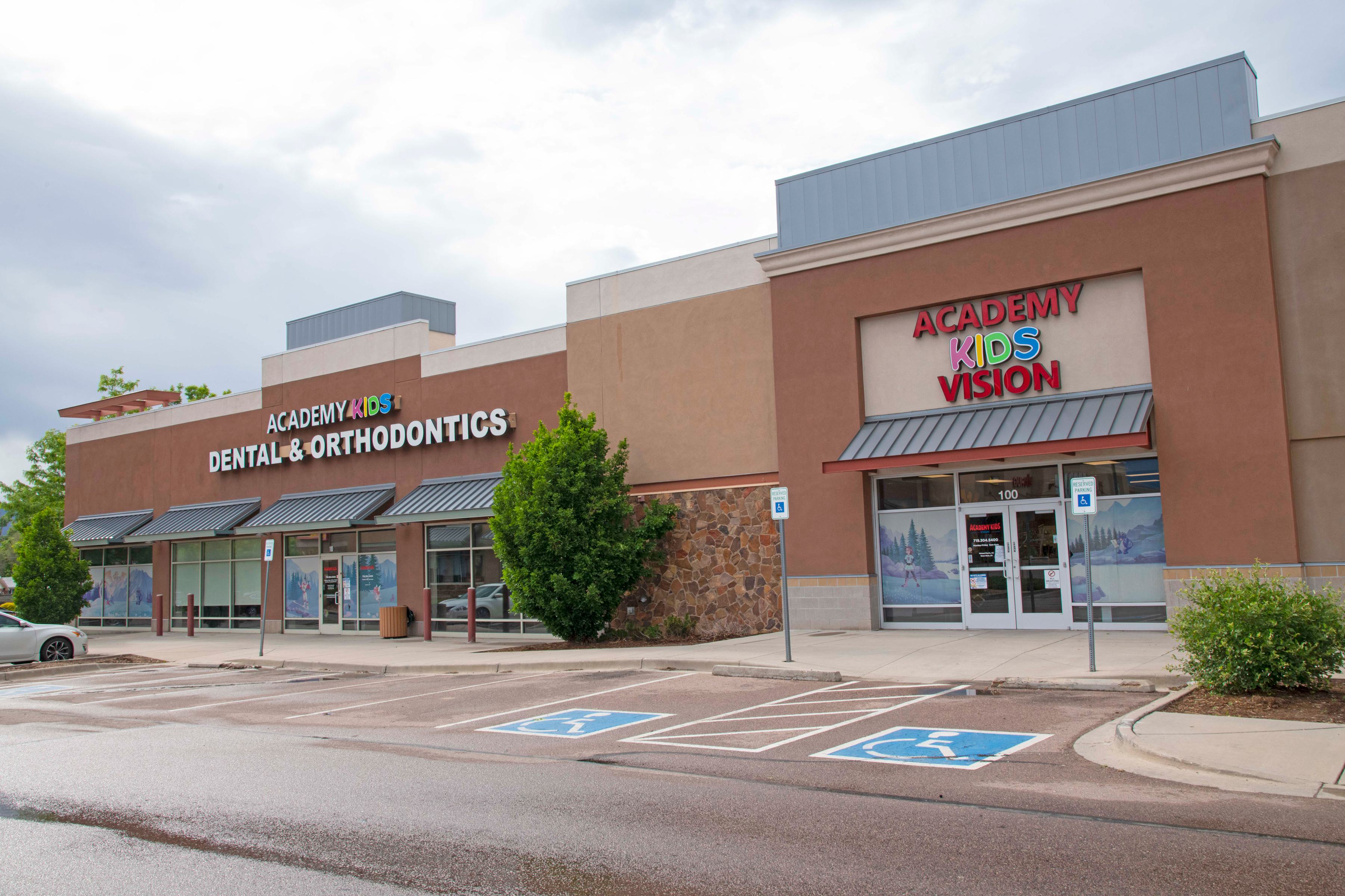 tan building with awnings with a colorful sign that says Academy Kids Dental, Orthodontics and Vision.