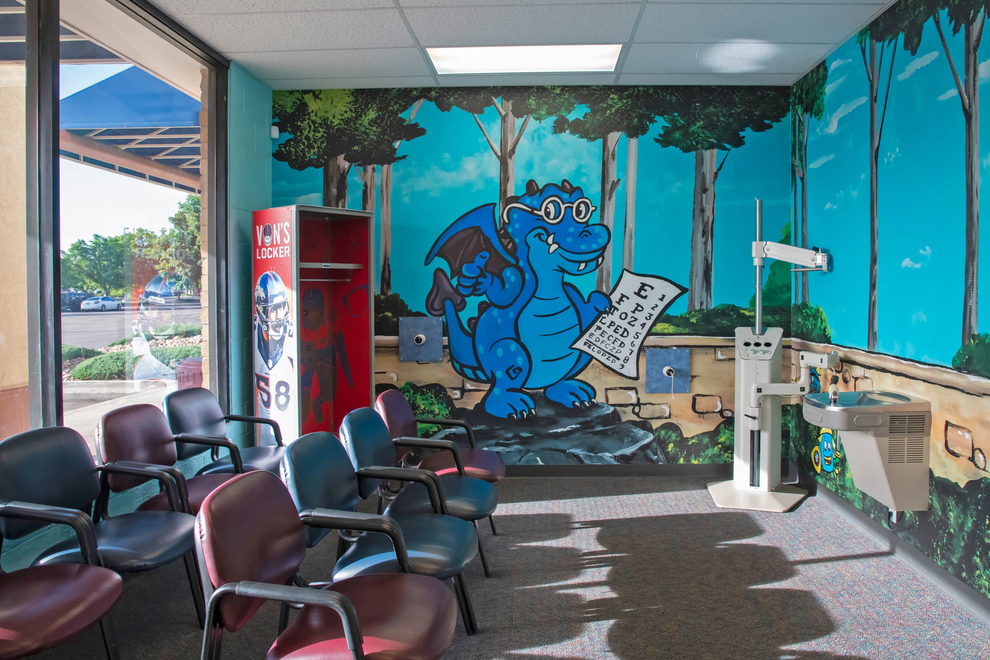 interior of a kid's dental office with a blue cartoon dragon on the wall