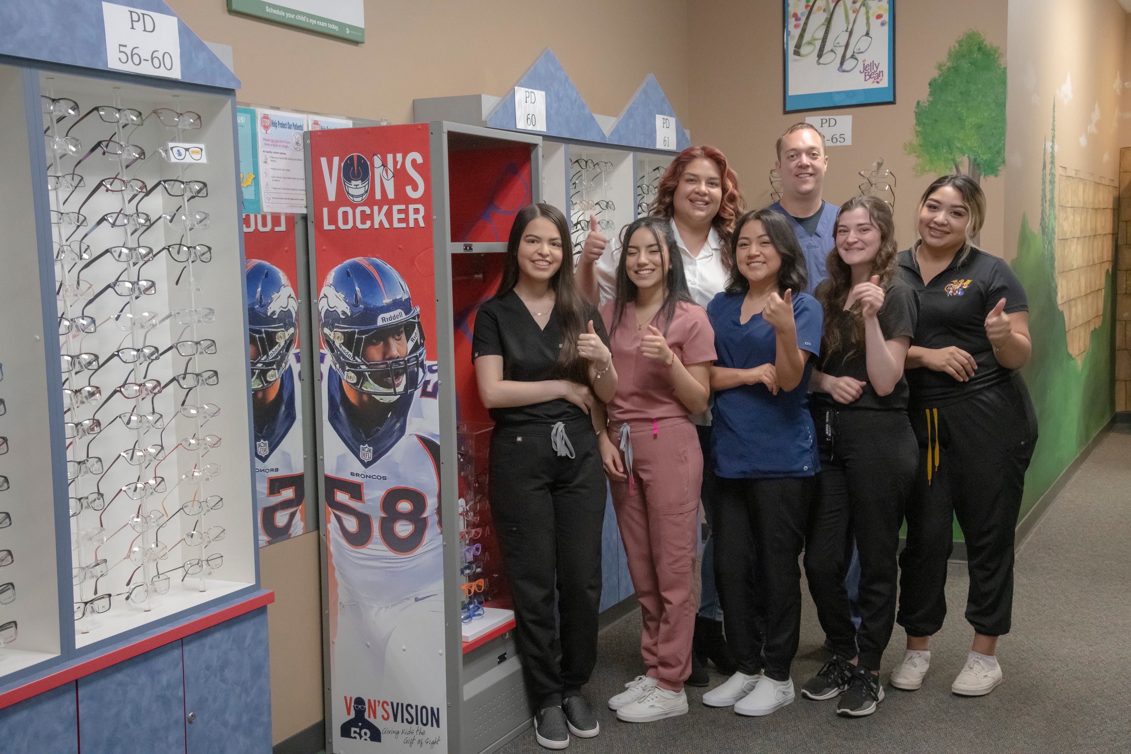 seven people in medical scrubs waving