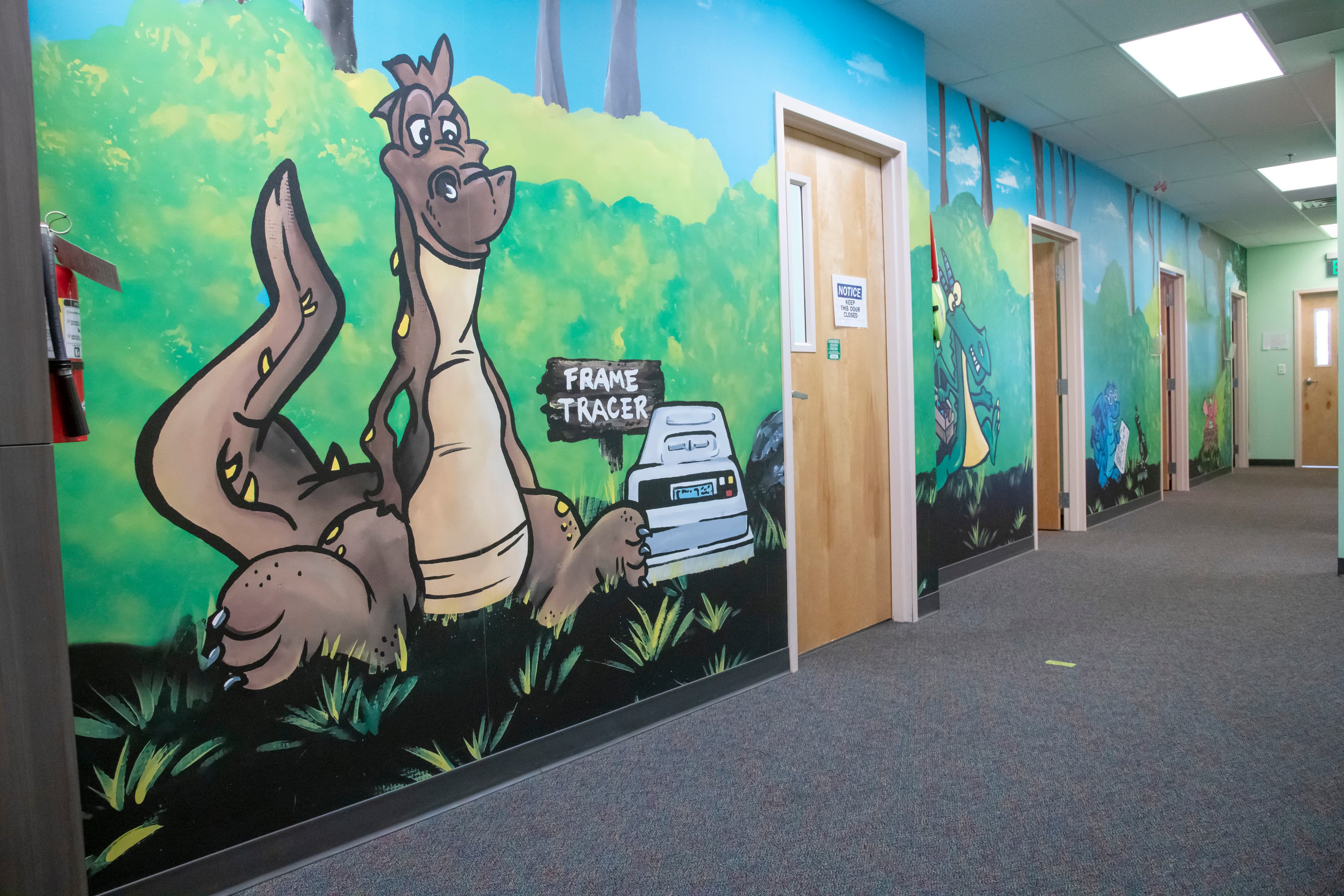 brown cartoon dragon on a wall in a hall way