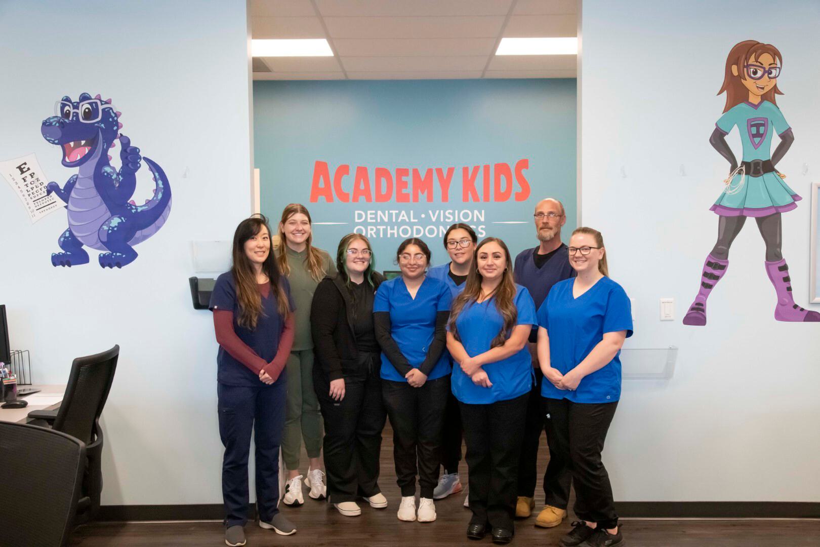 Seven staff members in scrubs in a optometrist office