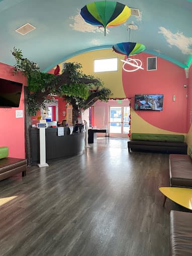 Dental office waiting room with appointment desk and multi colored pink and yellow walls