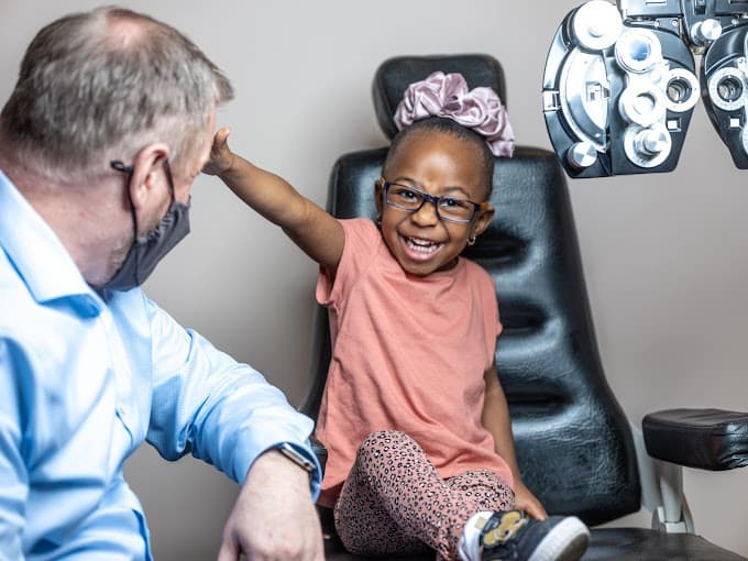 Optometrist with child laughing and having fun
