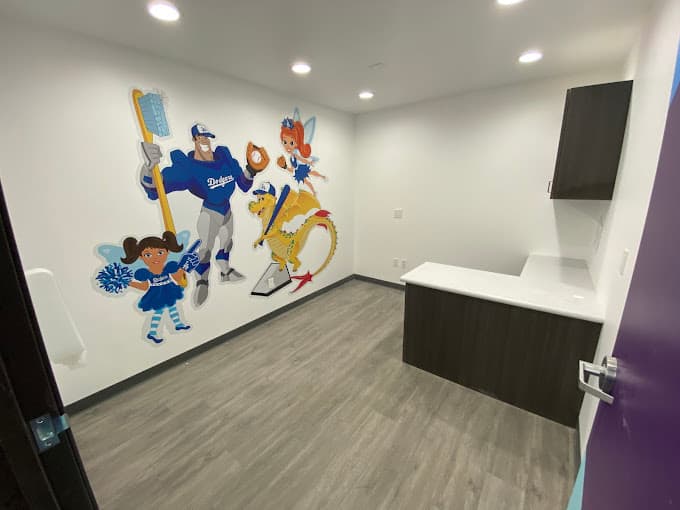 dental and orthodontics exam room with mural of on wall of Captain Smiles, Sparkle, Bracket, and Twinkle characters