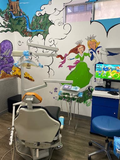 Dental exam room with one chair and a computer monitor and colorful mural depicting a princess in a green dress
