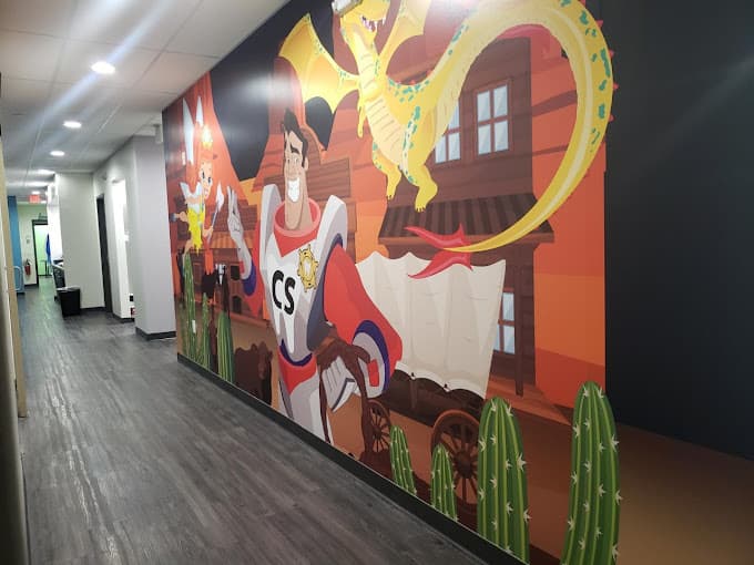 large, colorful hallway mural of Caption Smiles