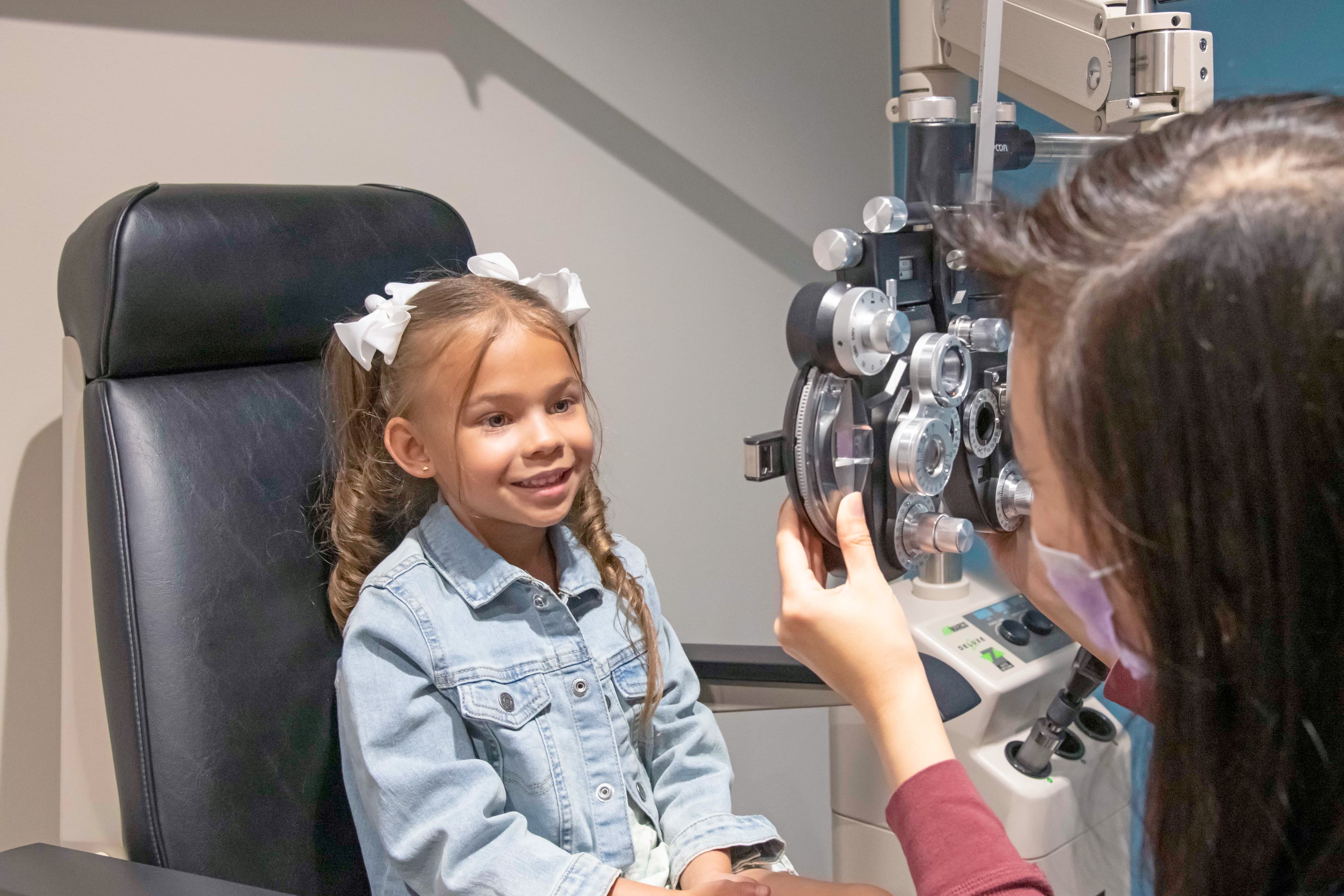 young girl smiling getting a children's eye exam