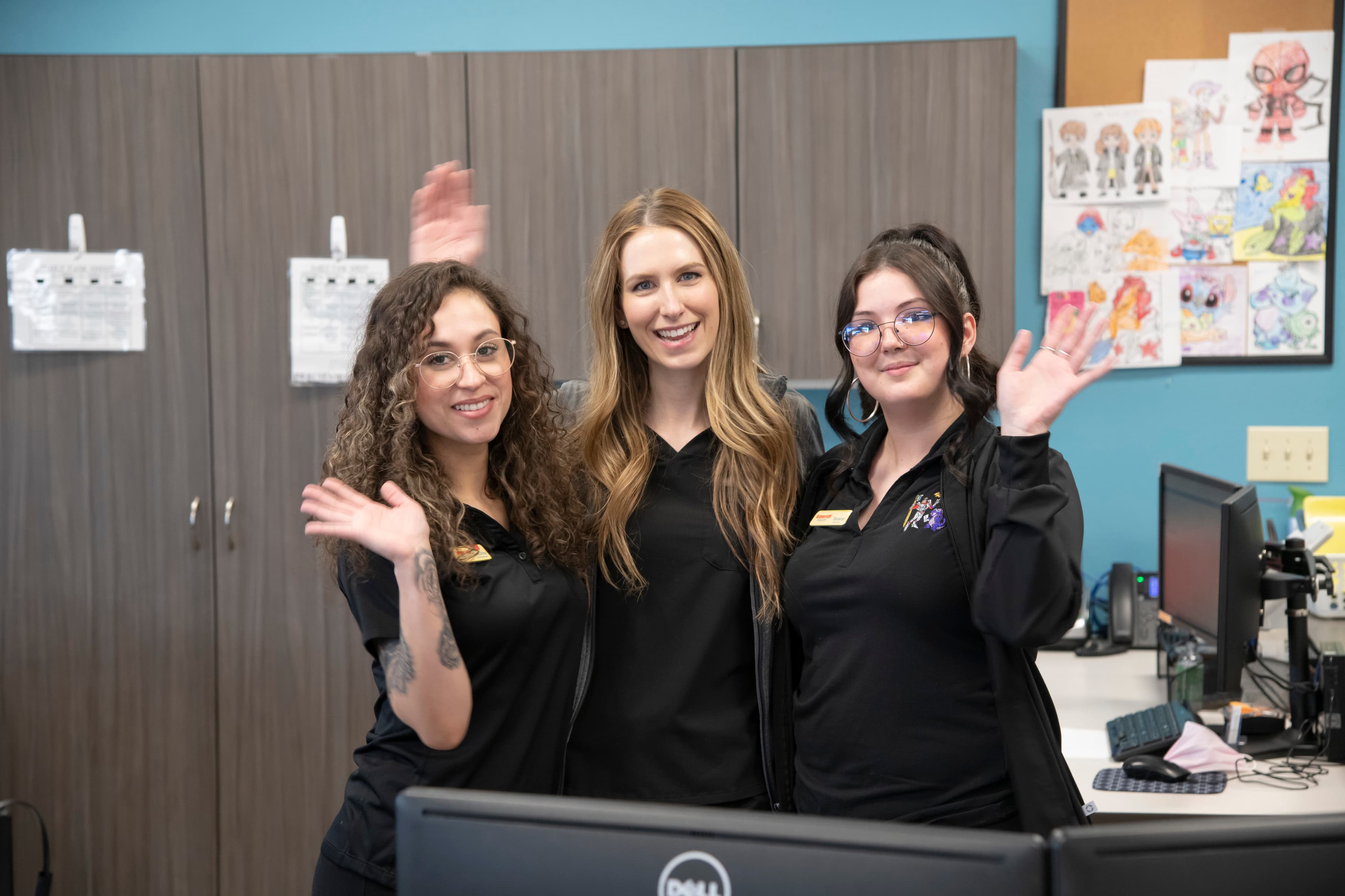 Pediatric dental care providers at our South Academy location in Colorado Springs. There are four women wearing black coverings and are happy and waving.